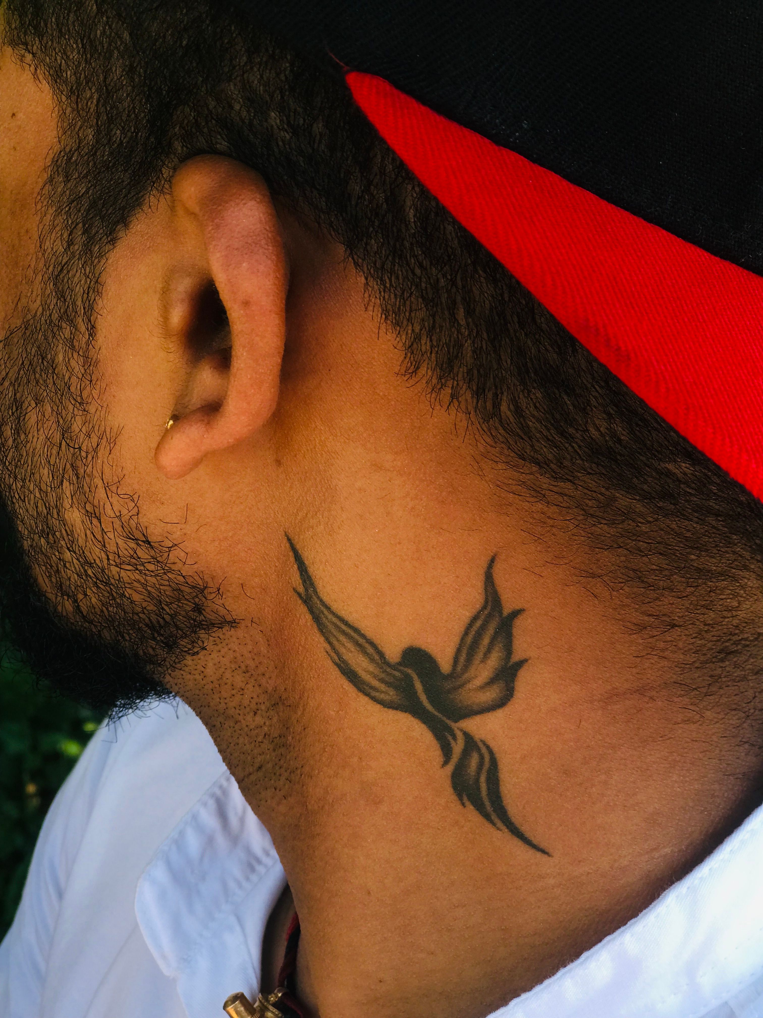 Tatuagem de silhueta de pássaro no pescoço em estilo minimalista